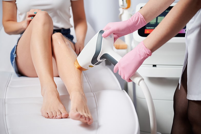 Woman receiving laser hair removal treatment in beauty salon.